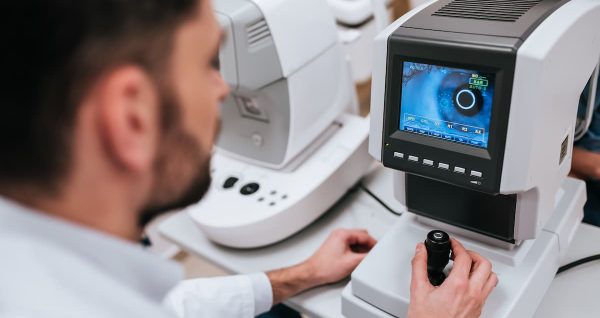 Nowoczesny autorefraktometr z ekranem LCD i podbródkiem w jasnym gabinecie okulistycznym