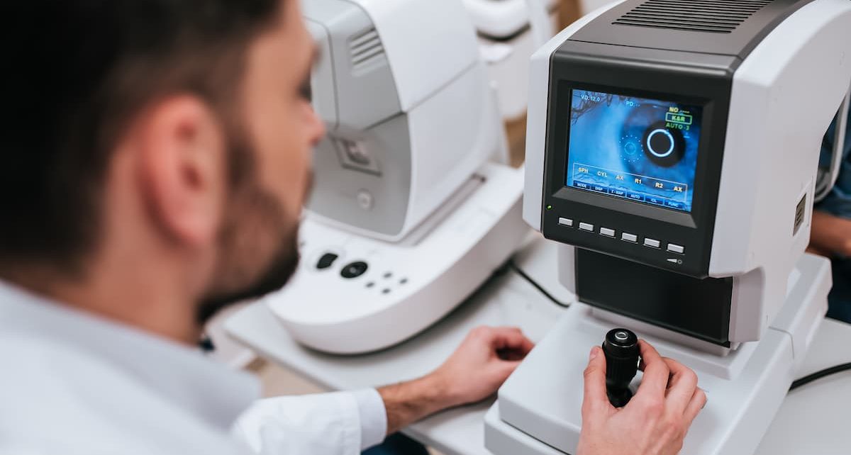 Nowoczesny autorefraktometr z ekranem LCD i podbródkiem w jasnym gabinecie okulistycznym