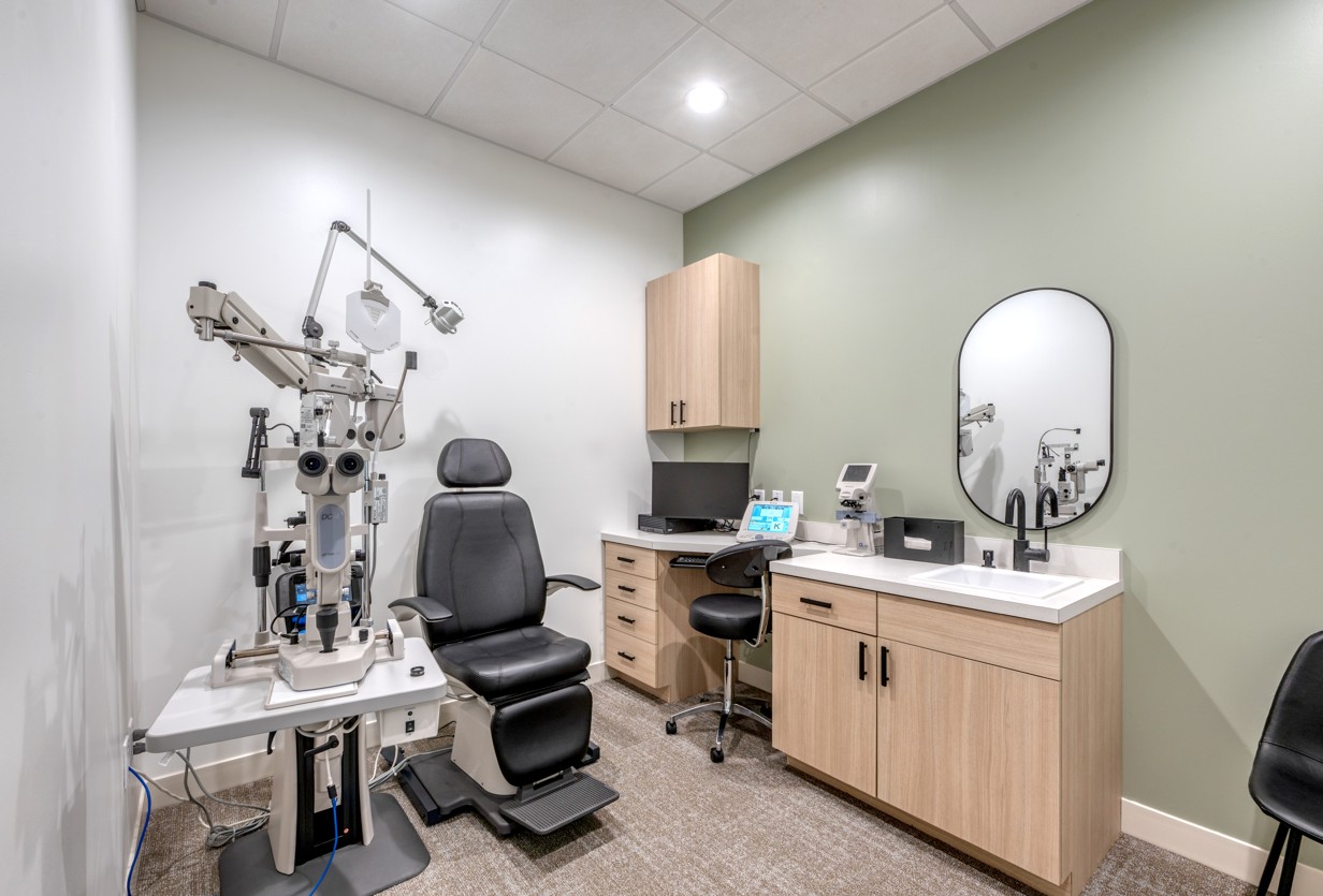 Pacjent z głową opartą na podbródku patrzący w otwór autorefraktometru